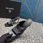 Black mule sandals with logo-print strap, open toe, and slim stiletto heel