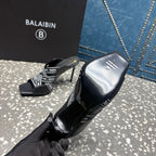 Black slide sandals with logo-print upper and shiny stiletto heel, open toe