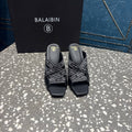 Black slide sandals with open toe and logo-print strap, square platform heel