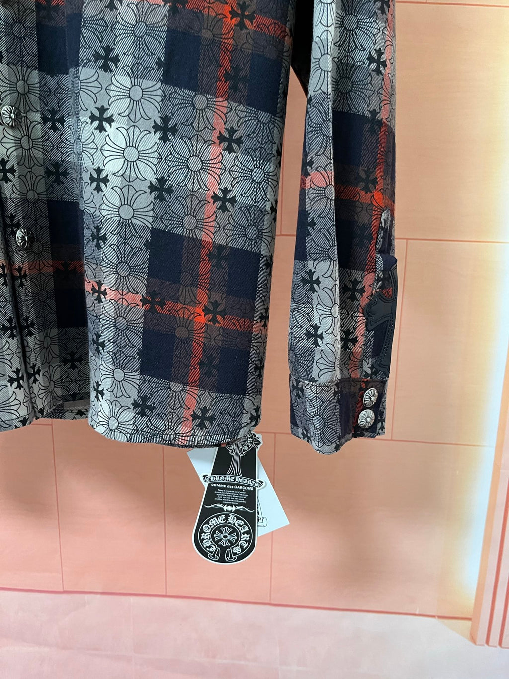 Long-sleeve shirt hem with hanging tag and blue floral plaid pattern