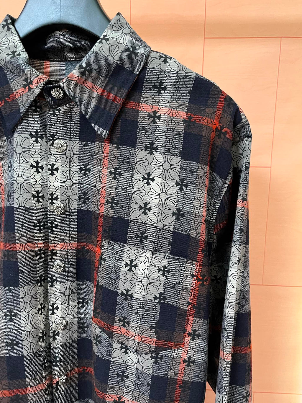 Long-sleeve shirt front with navy plaid squares over white floral print