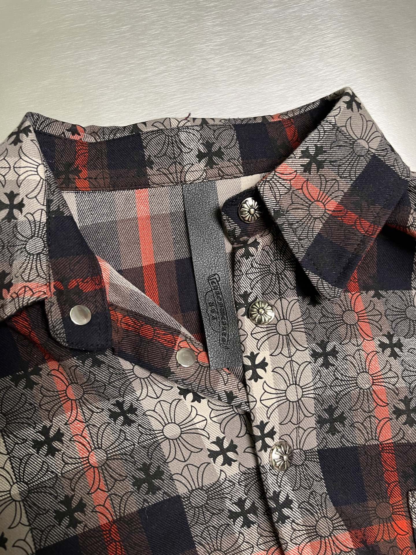 Shirt collar and button placket with dark plaid trim and floral print