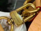 Louis Vuitton branded gold-tone hardware clasp on bag strap