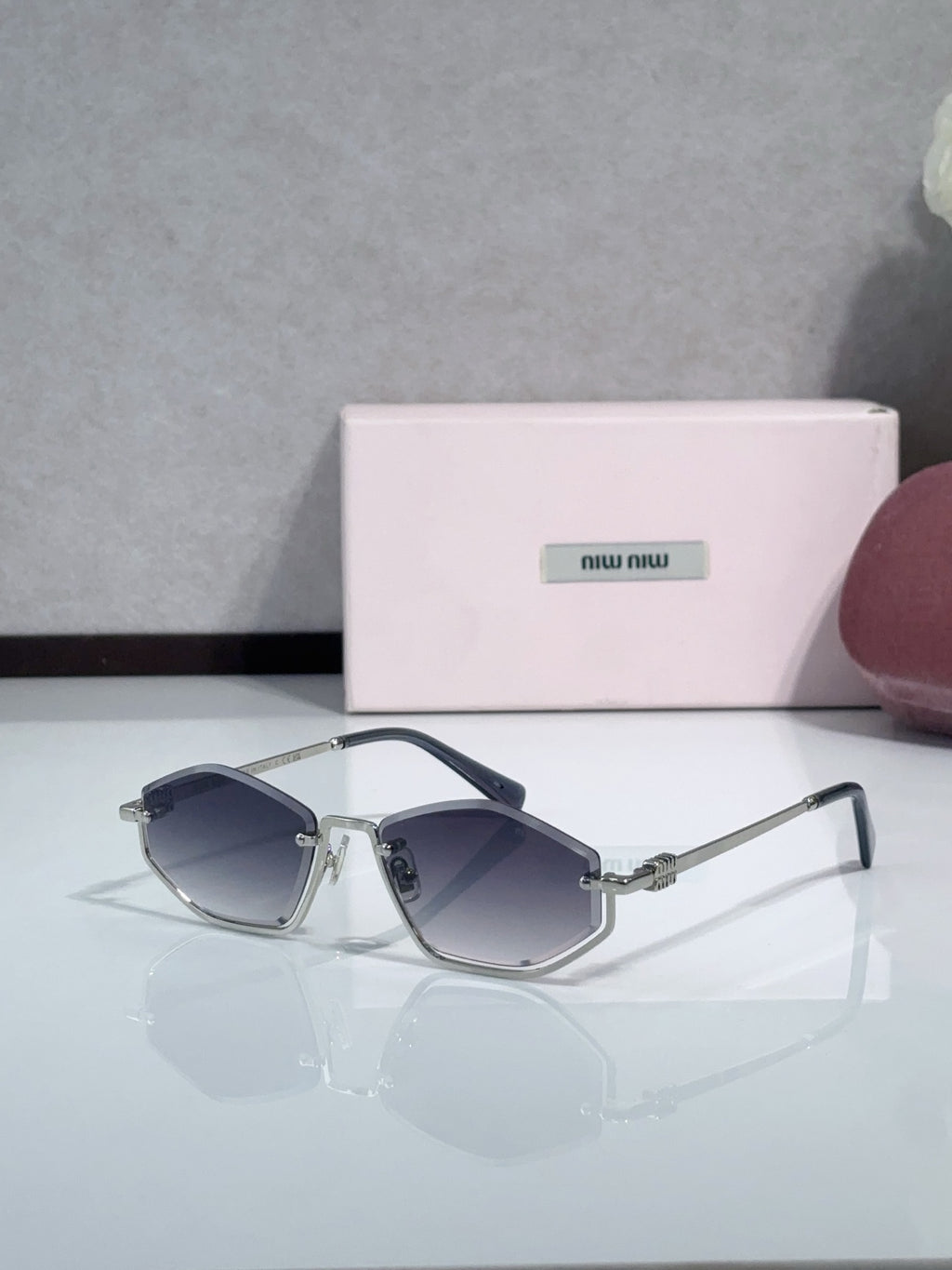 Miu Miu sunglasses with navy lenses, silver-tone frames, and dark blue temples