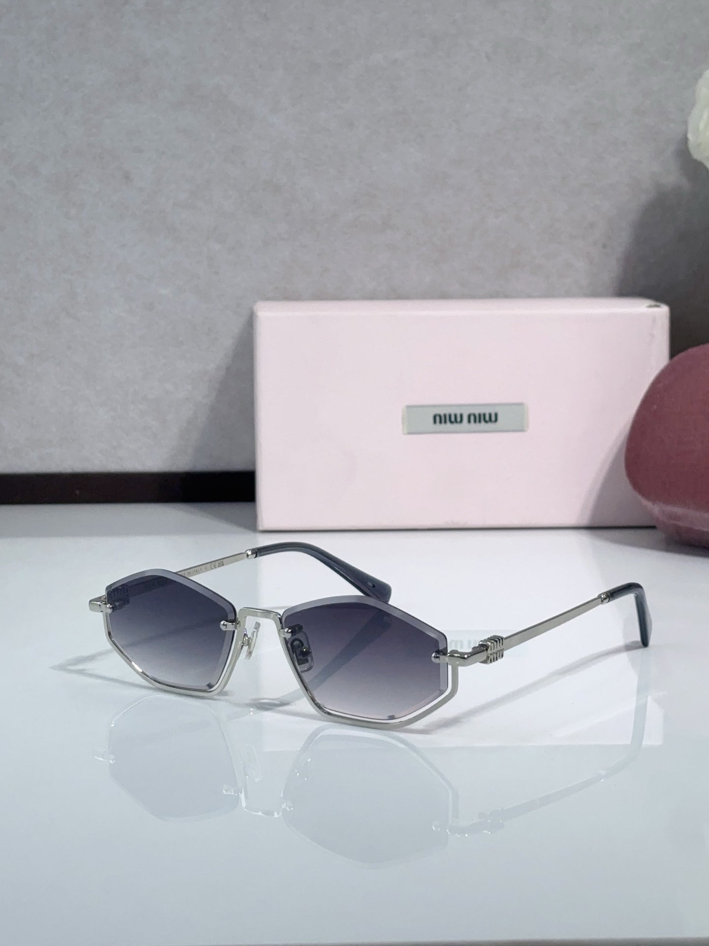Miu Miu sunglasses with navy lenses, silver-tone frames, and dark blue temples