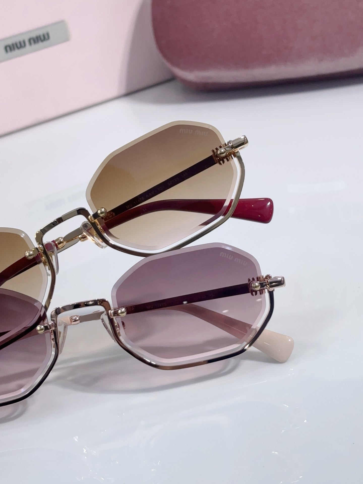 Hexagonal sunglasses side view with pink and brown tinted lenses on gold frames
