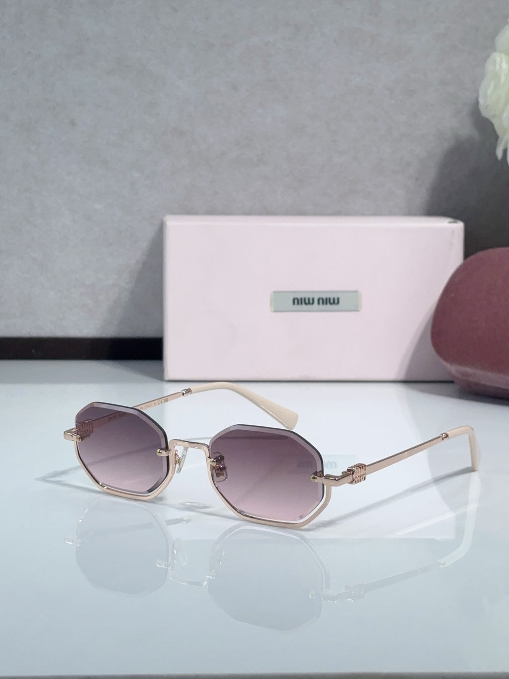 Gold metal hexagonal sunglasses with light brown lenses and cream temple tips