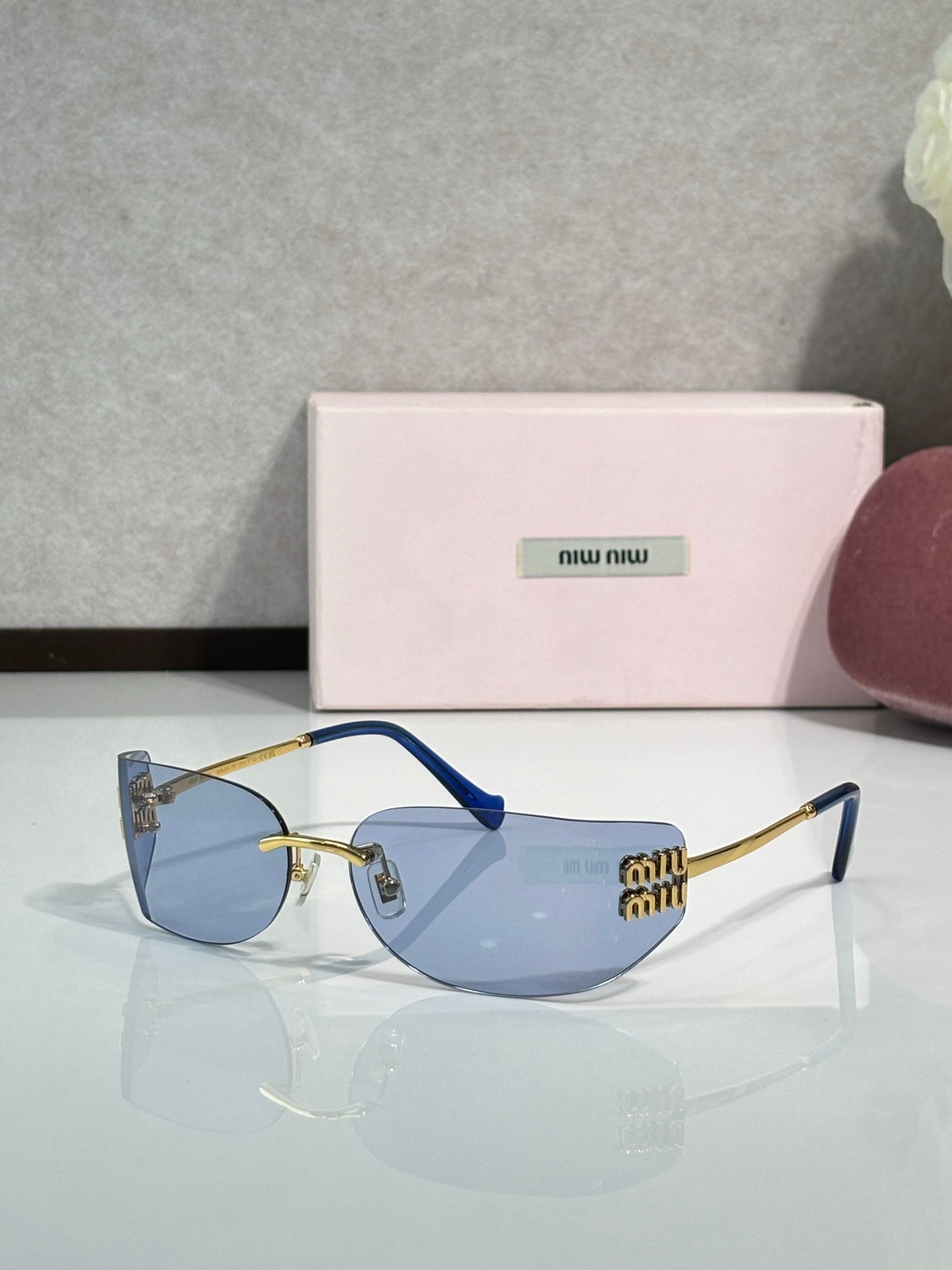 MiuMiu sunglasses with dark blue lenses, blue temples, gold-tone accents