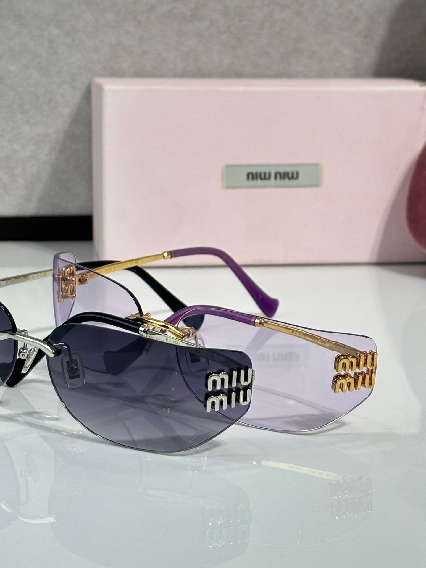 MiuMiu sunglasses with dark blue lenses, gold frame and purple accents