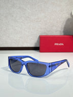 Prada glasses with blue cat-eye frames and dark tinted lenses