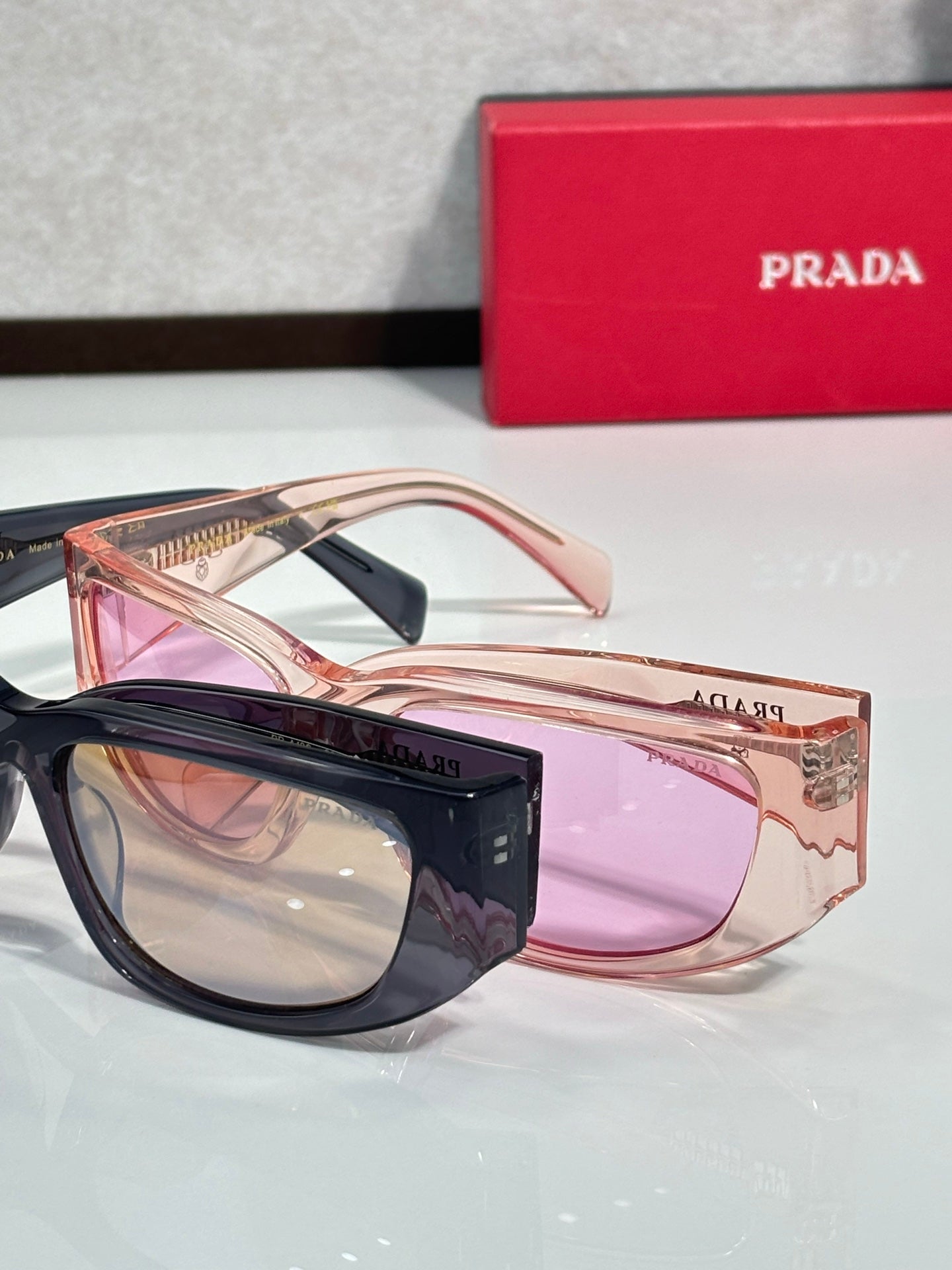 Prada glasses with rose frames and pink tinted lenses, angled view