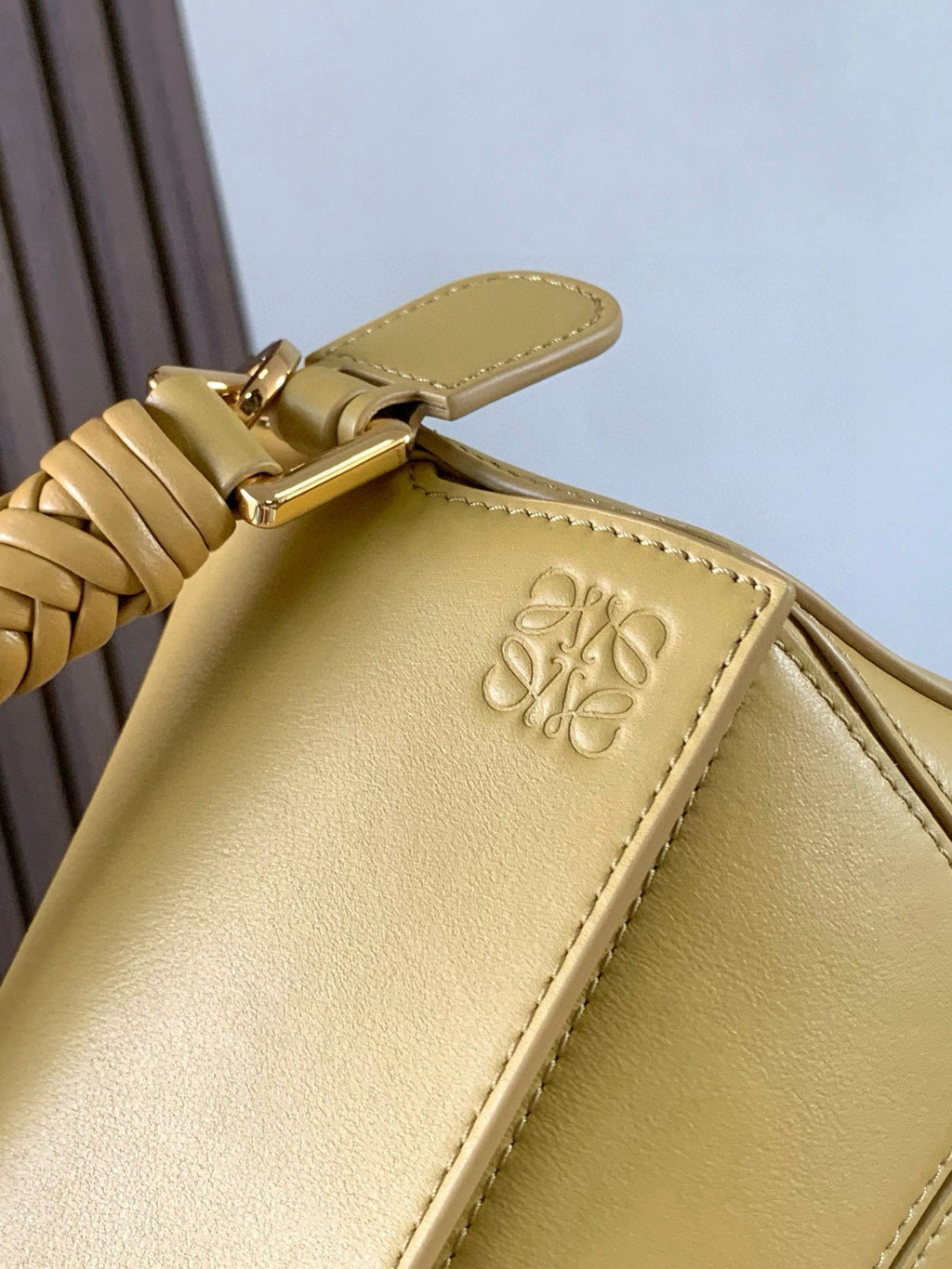 Loewe light yellow leather bag close-up with embossed logo on top panel