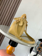 Loewe light yellow leather mini bag with braided handle, flap front, and shoulder strap