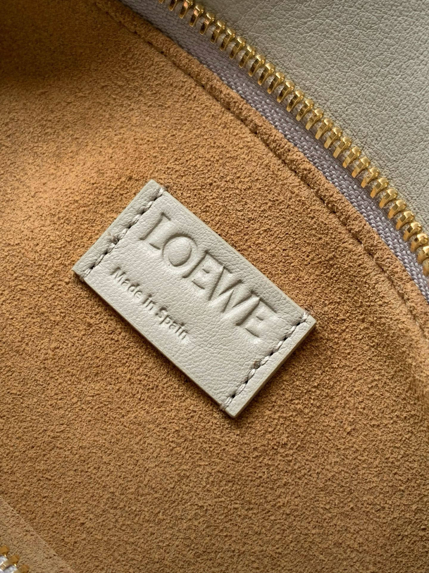 Loewe logo label on tan lining with stitched border.