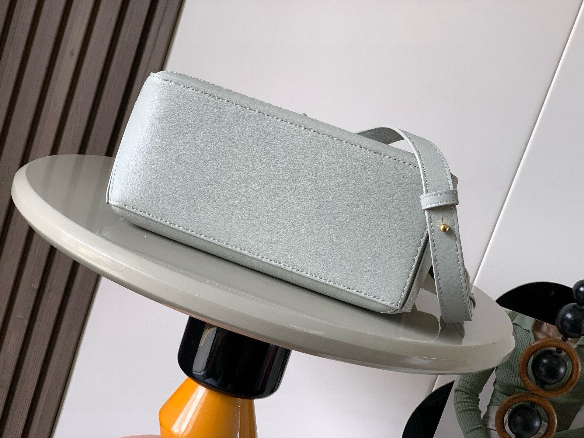 Loewe light blue mini shoulder bag with long strap and rounded front panel.