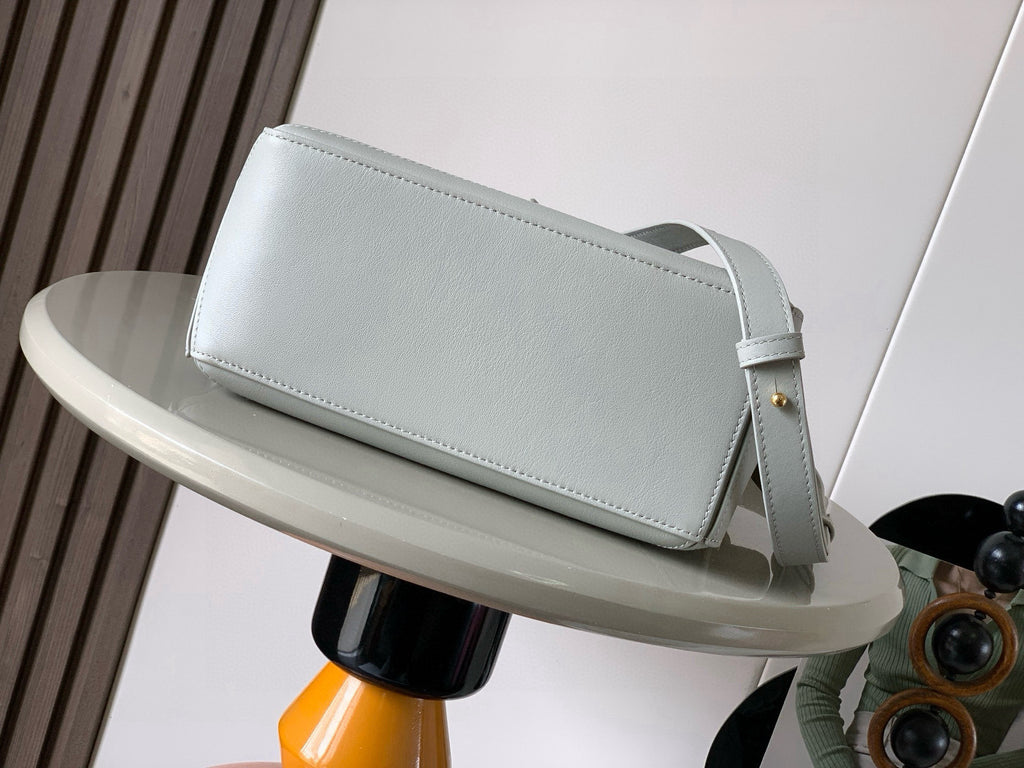 Light blue leather shoulder bag with flap-style front panel and adjustable strap