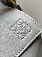 Light blue leather bag with embossed logo on front panel and stitched border