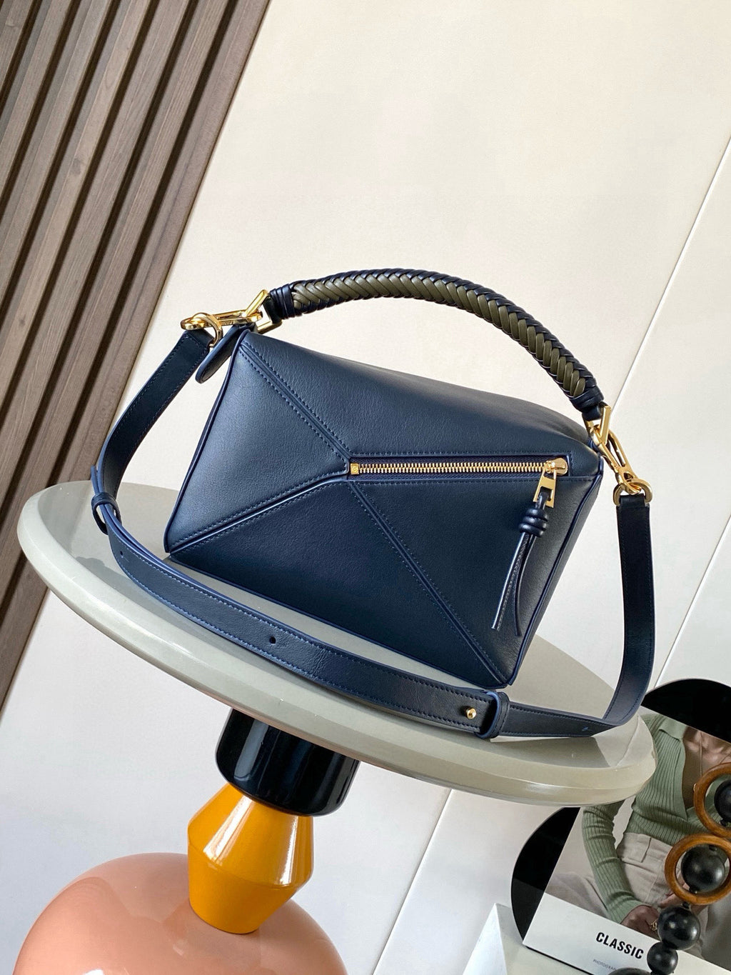 Blue leather hobo bag with braided handle, front zipper pocket, and gold hardware