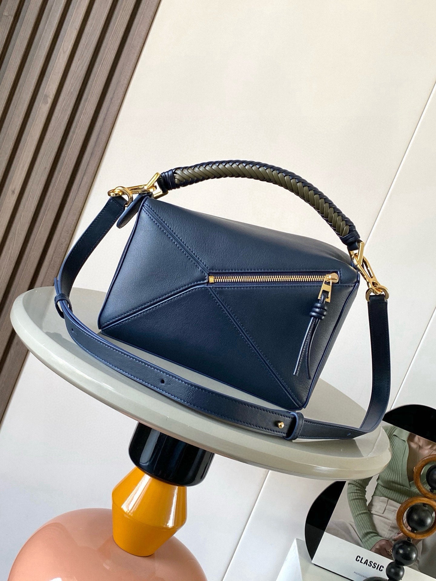 Blue leather hobo bag with braided handle, front zipper pocket, and gold hardware