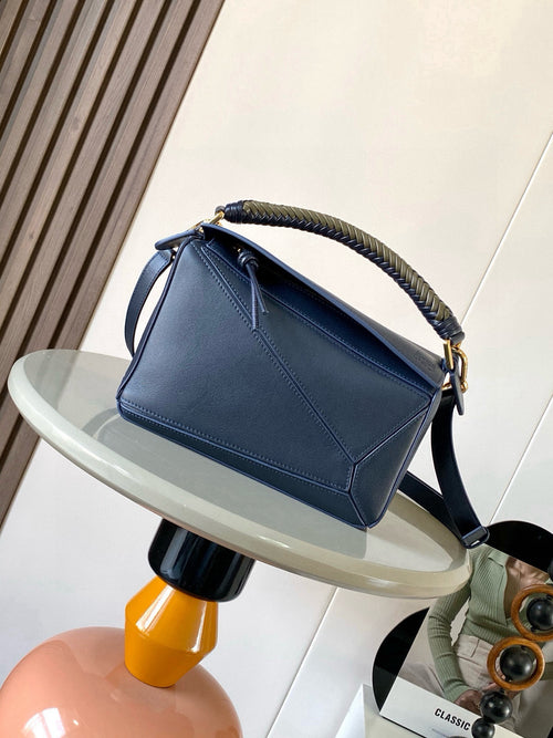 Blue leather crossbody bag with braided top handle and gold hardware