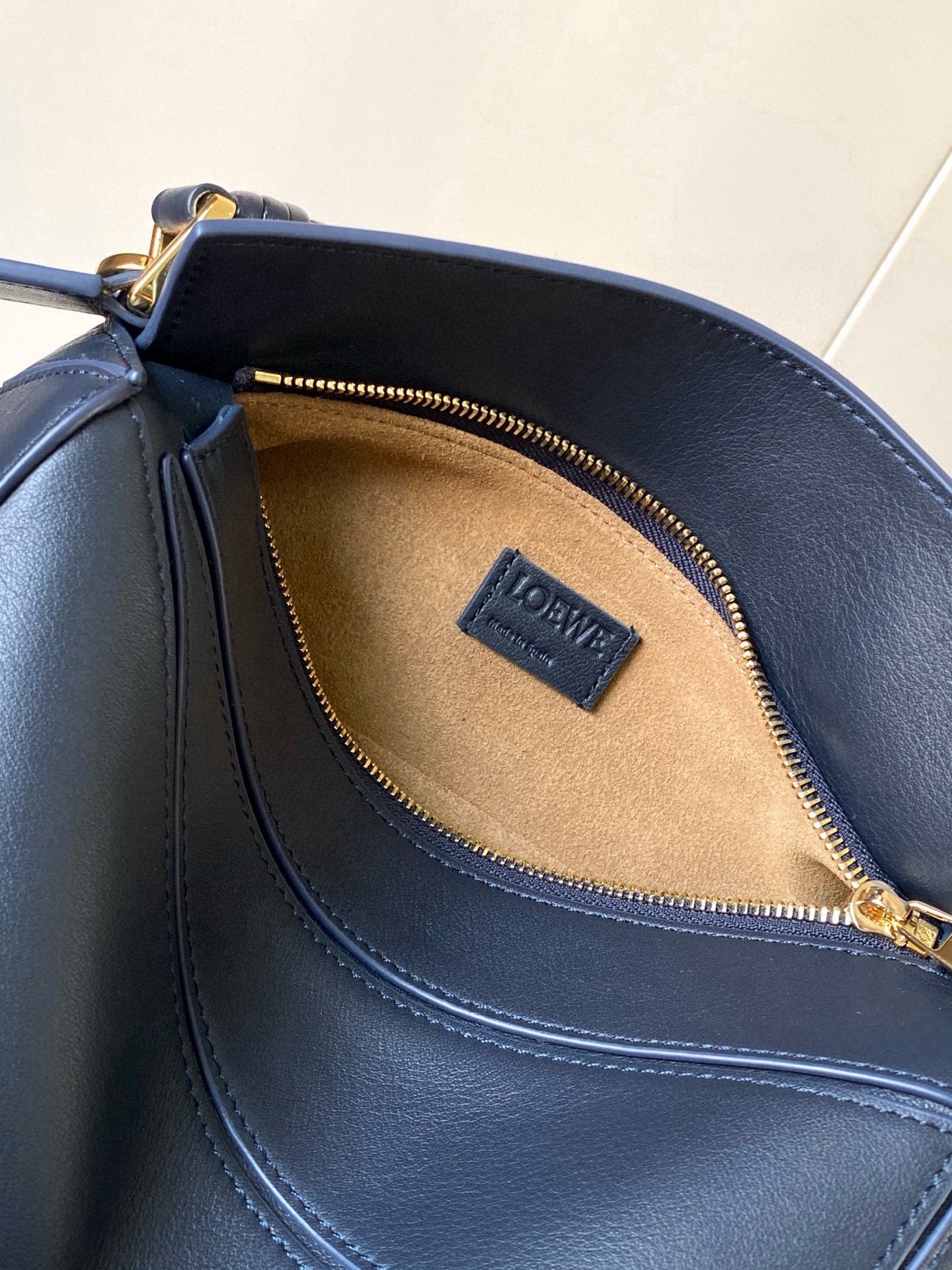 Blue leather handbag interior with tan lining and zippered compartment.