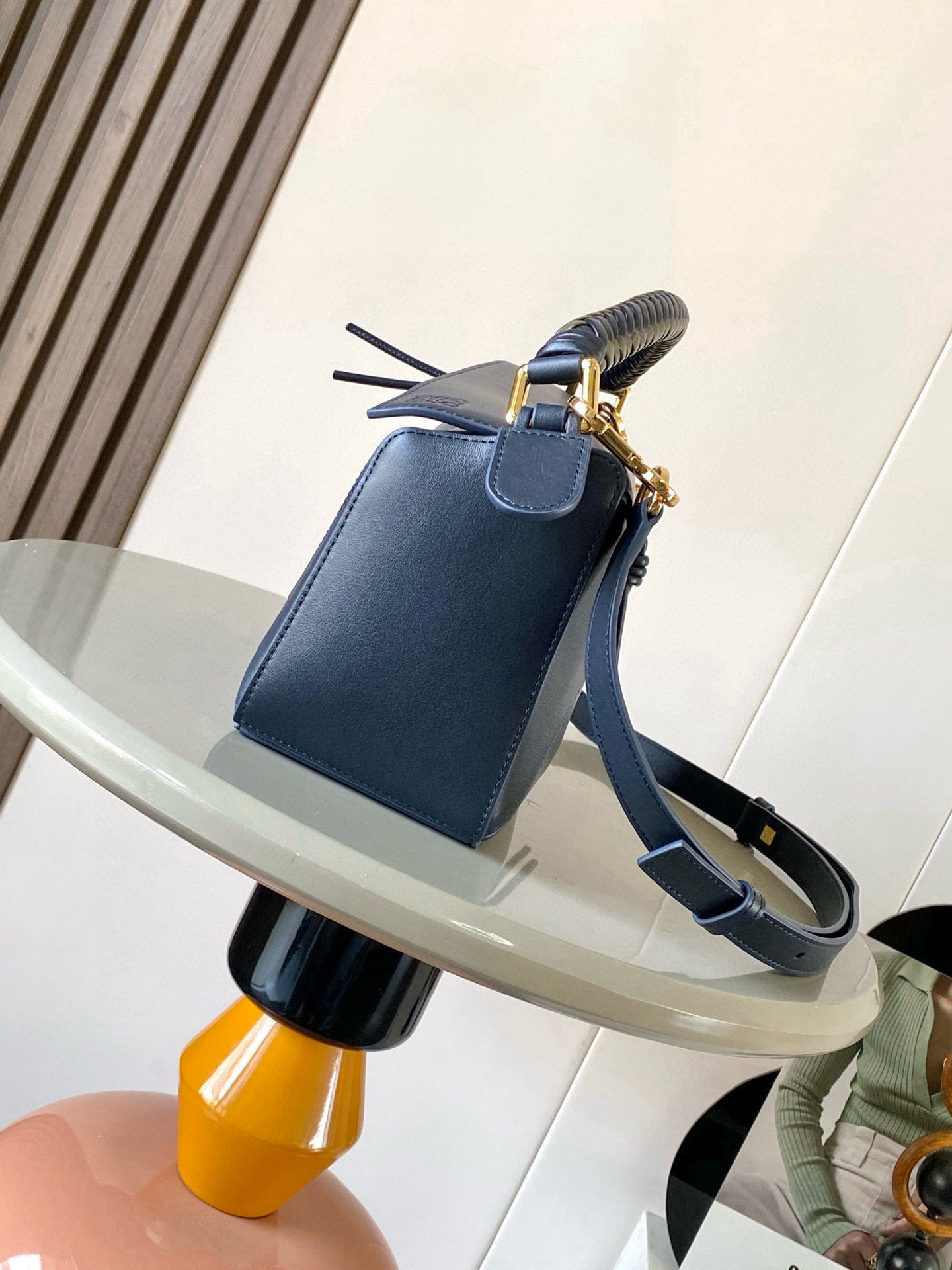 Blue leather crossbody bag with short strap, braided handle, and gold clasp