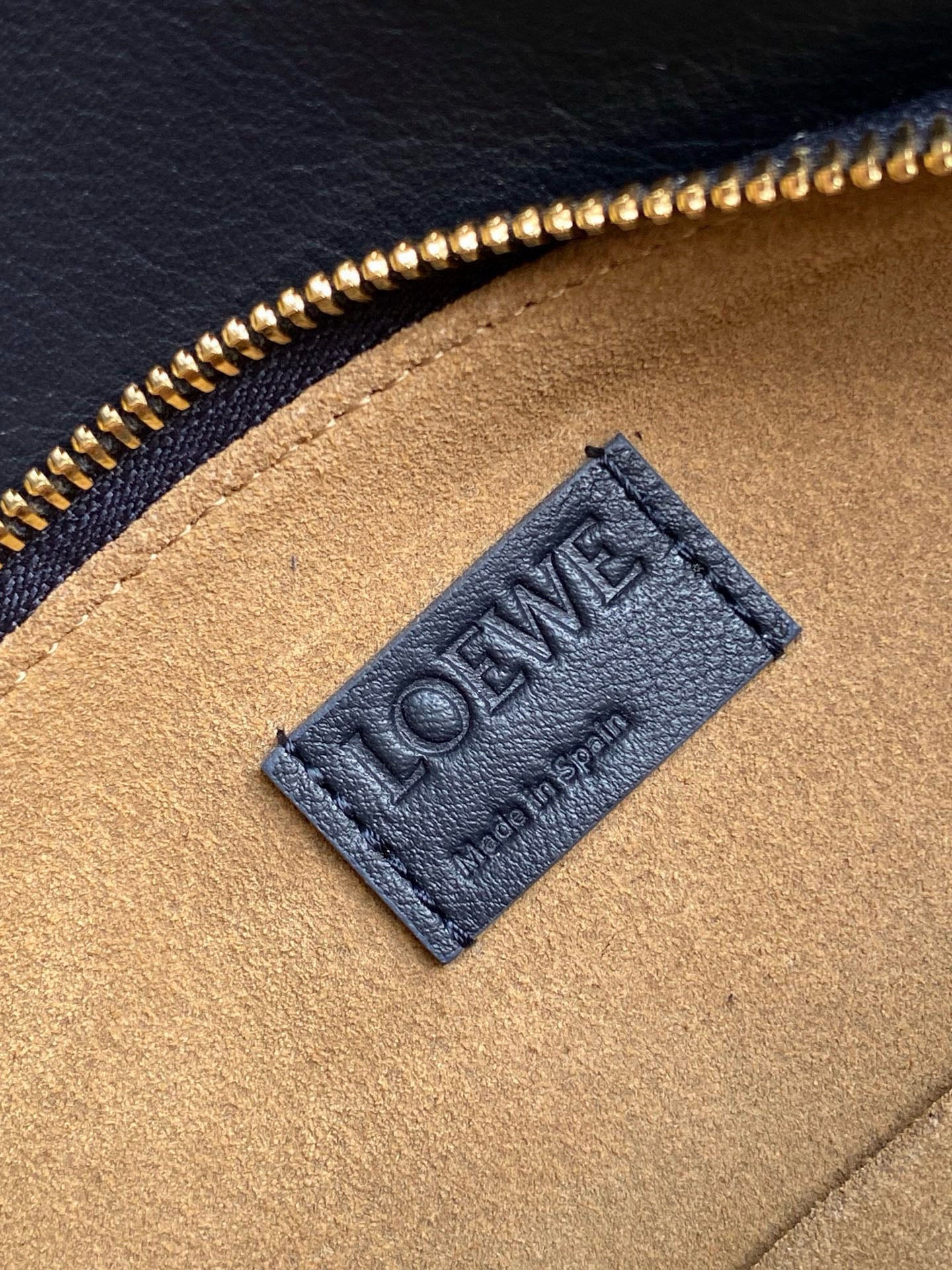 Blue leather bag lining label with Loewe logo on tan panel
