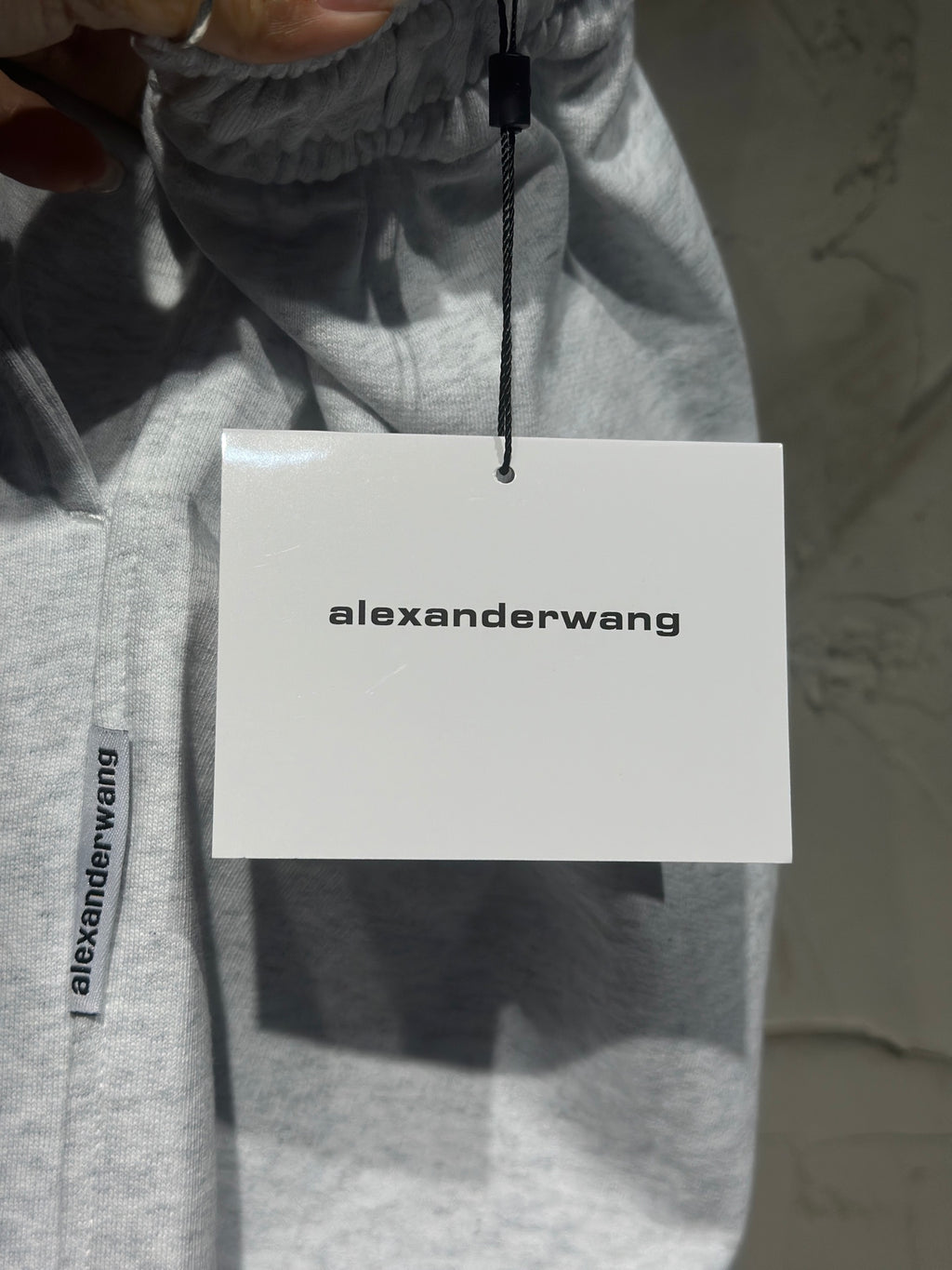 Heather-gray sweatpants with alexanderwang hang tag attached to the waistband.