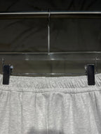 Heather-gray sweatpants waistband close-up with elastic gathered detail and drawstring.
