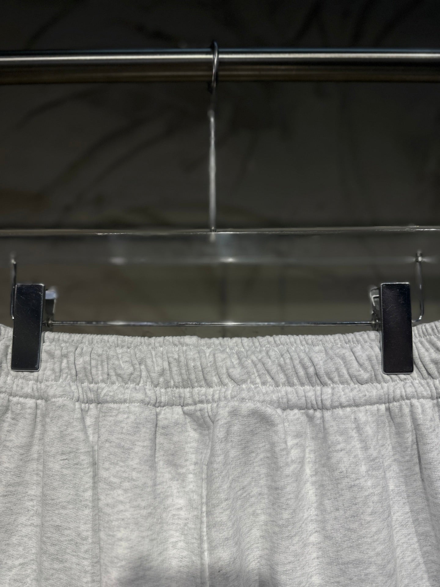 Heather-gray sweatpants waistband close-up with elastic gathered detail and drawstring.