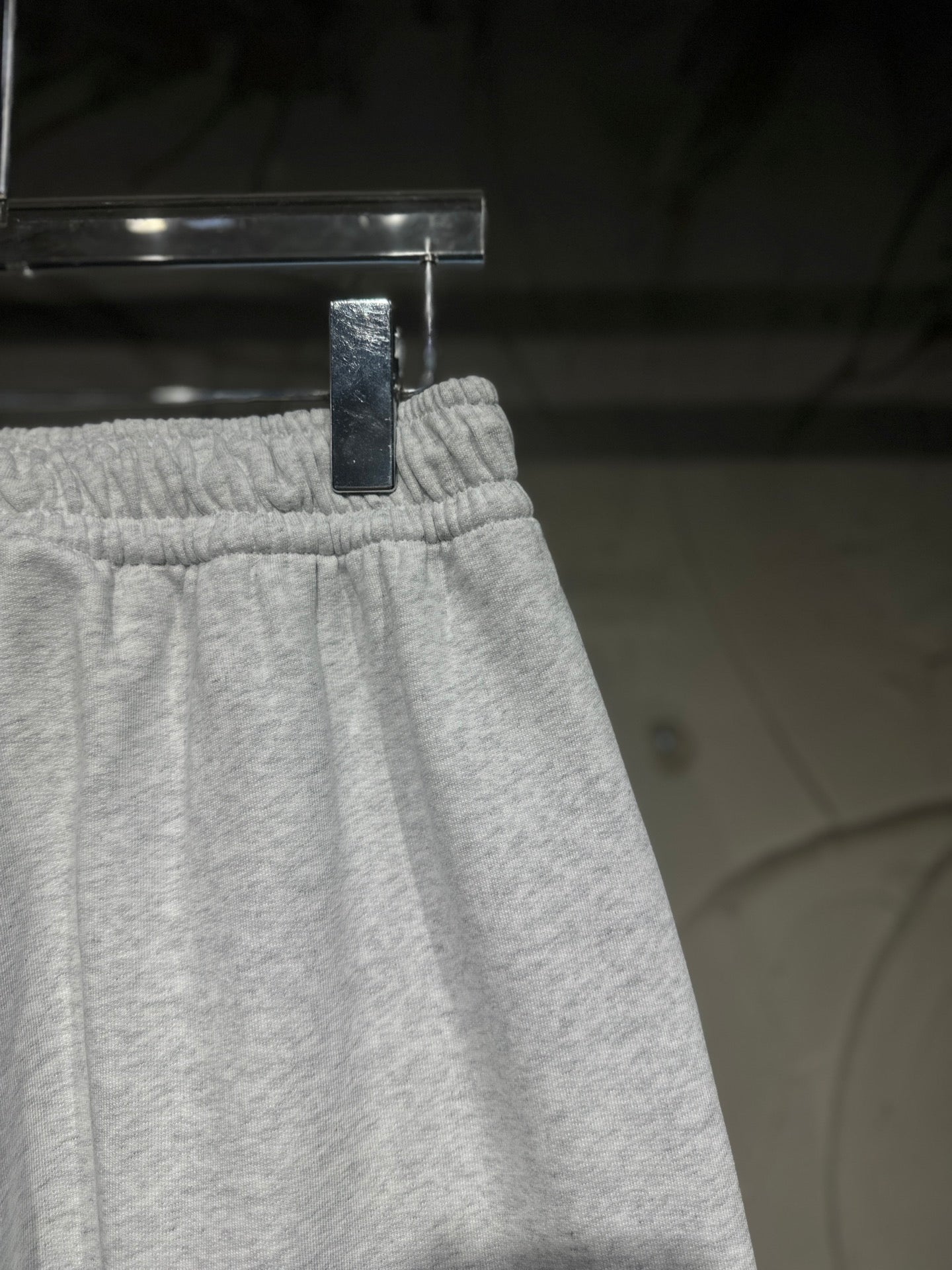 Heather-gray sweatpants upper section with elastic waistband and side seam detail.
