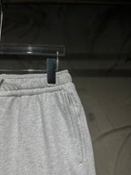 Heather-gray sweatpants waistband close-up with elastic band and stitched seam.
