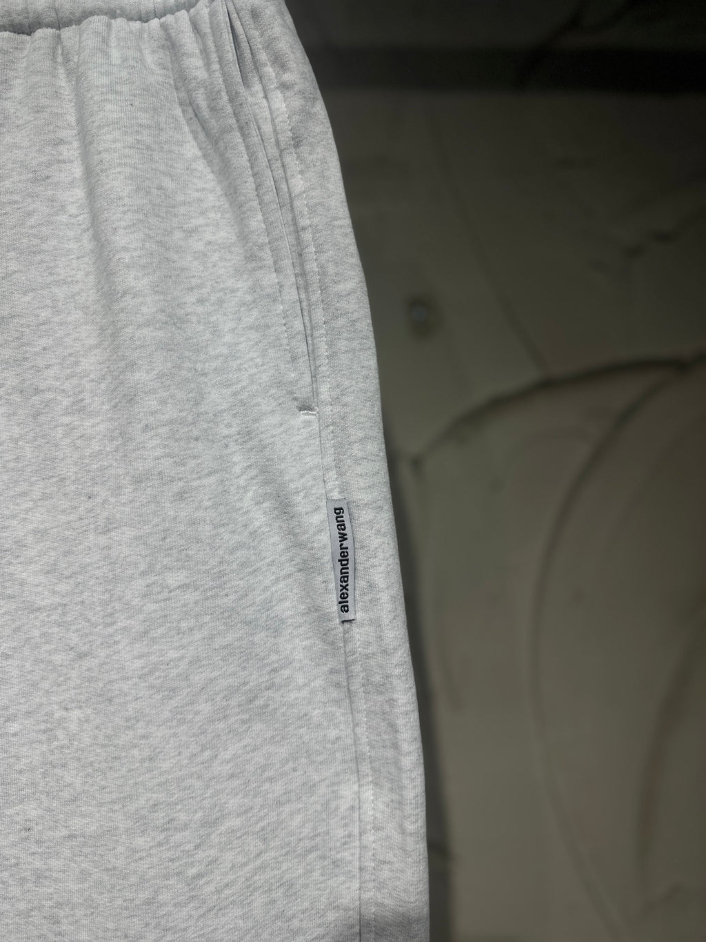 Heather-gray sweatpants with vertical side logo label and relaxed straight-leg fit.