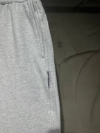 Heather-gray sweatpants with vertical side logo label and relaxed straight-leg fit.