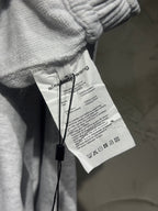 Heather-gray sweatpants with interior care label showing care and composition text.