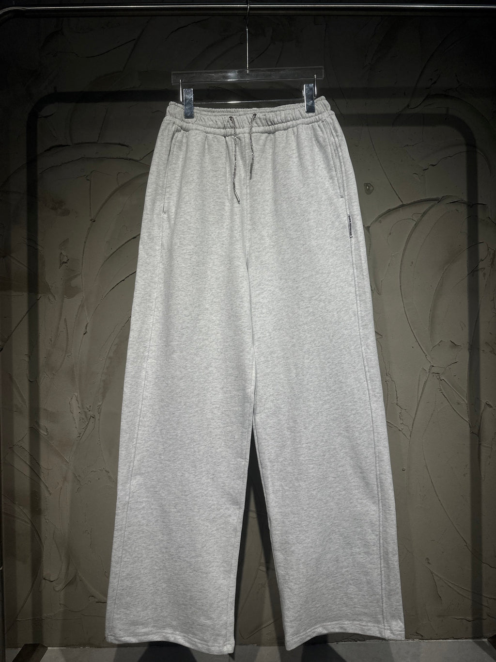 Heather-gray sweatpants with elastic waistband, drawstring, and wide straight legs.