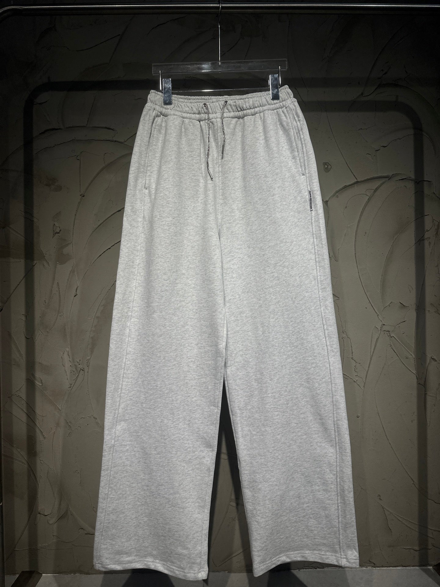 Heather-gray sweatpants with elastic waistband, drawstring, and wide straight legs.