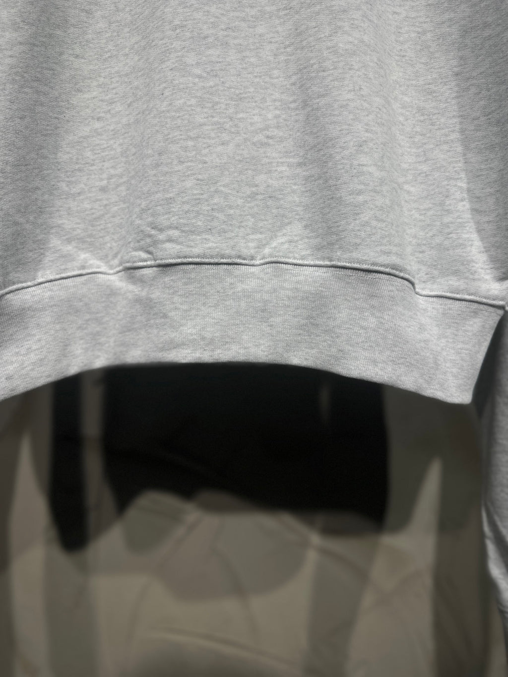 Light gray sweatshirt sleeve hem with ribbed cuff and curved bottom