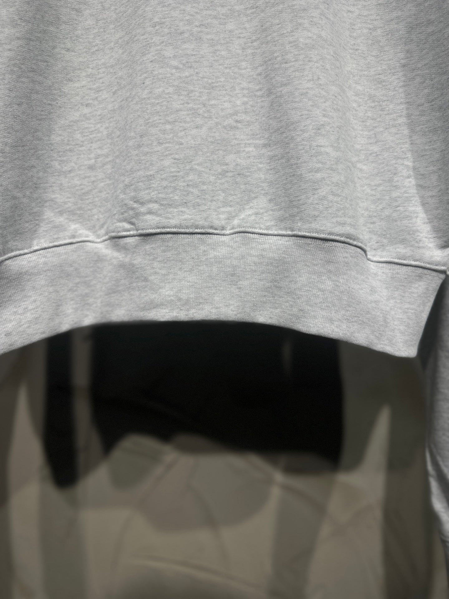 Light gray sweatshirt sleeve hem with ribbed cuff and curved bottom