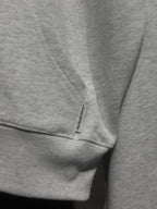 Light gray hoodie sleeve cuff with small printed label tag