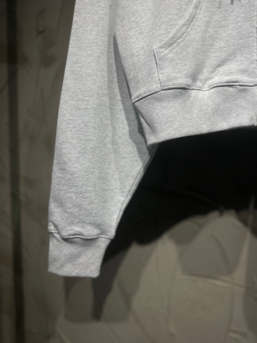 Light gray long-sleeve hoodie hem and sleeve opening with stitched cuff