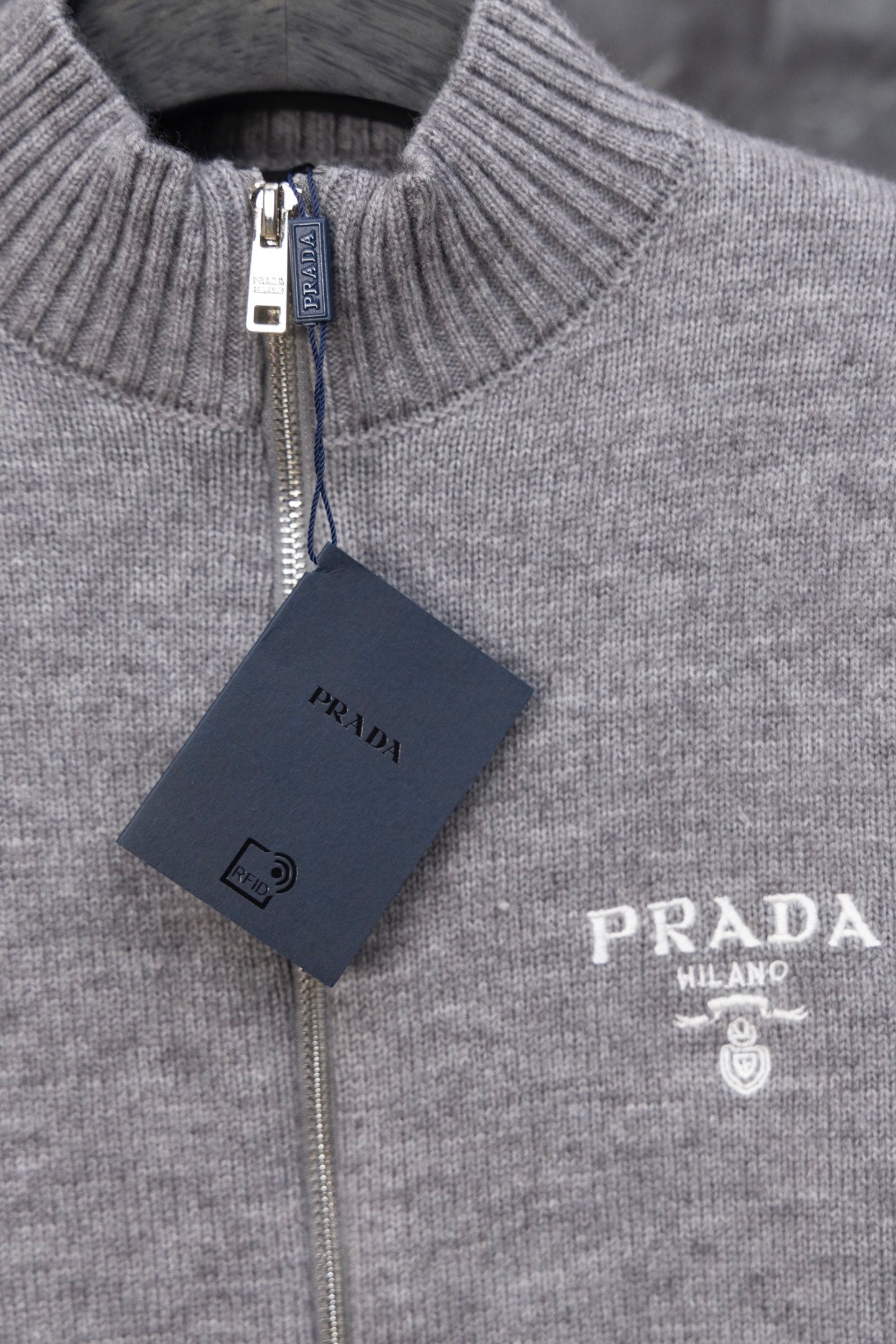 Gray Prada knit zip sweater close-up of ribbed stand collar, PRADA logo and tag