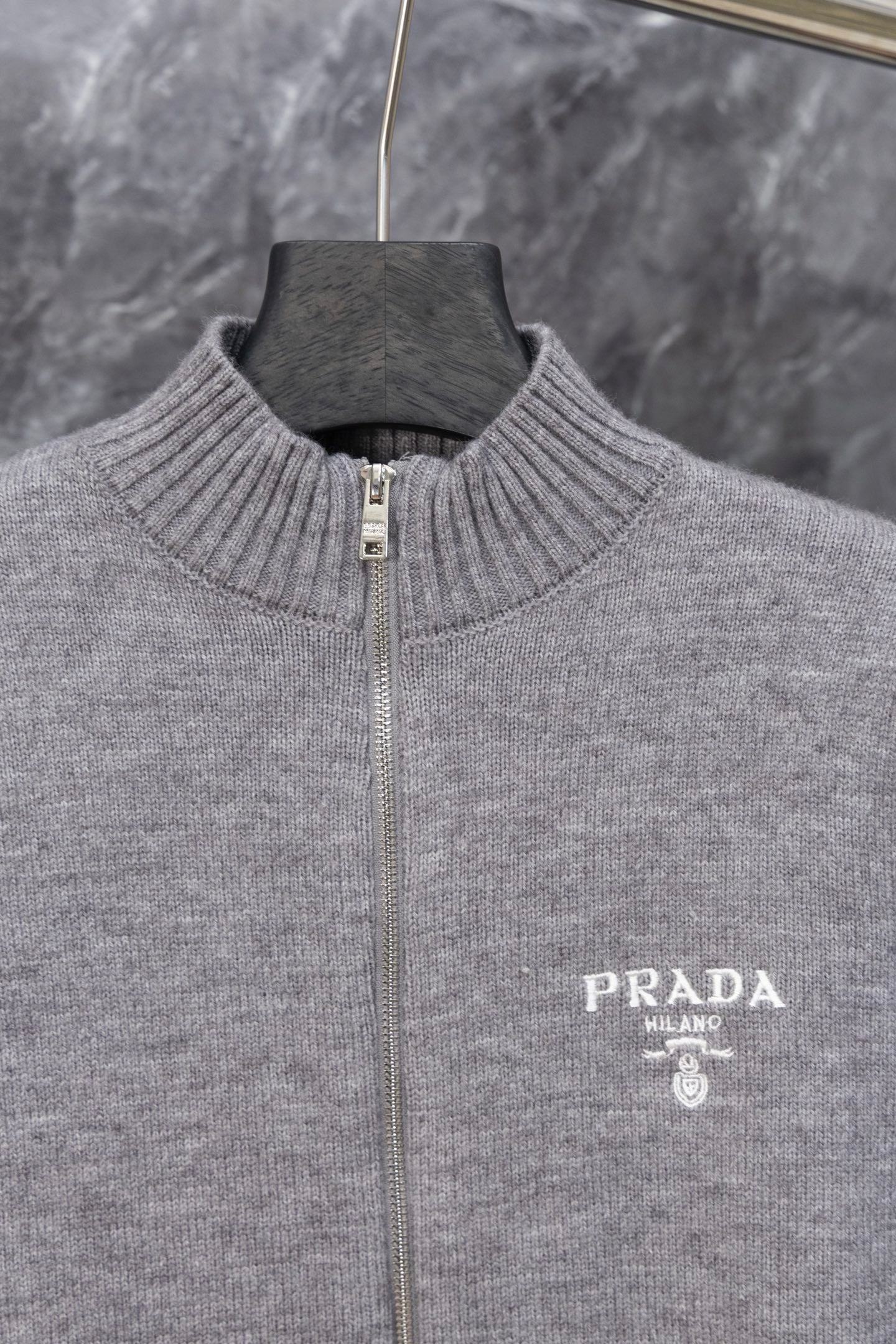 Gray Prada knit zip sweater front close-up with PRADA MILANO logo