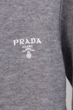 Gray Prada knit sweater chest close-up with PRADA MILANO logo and crest