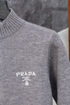 Gray Prada knit sweater shoulder and chest close-up with PRADA MILANO logo