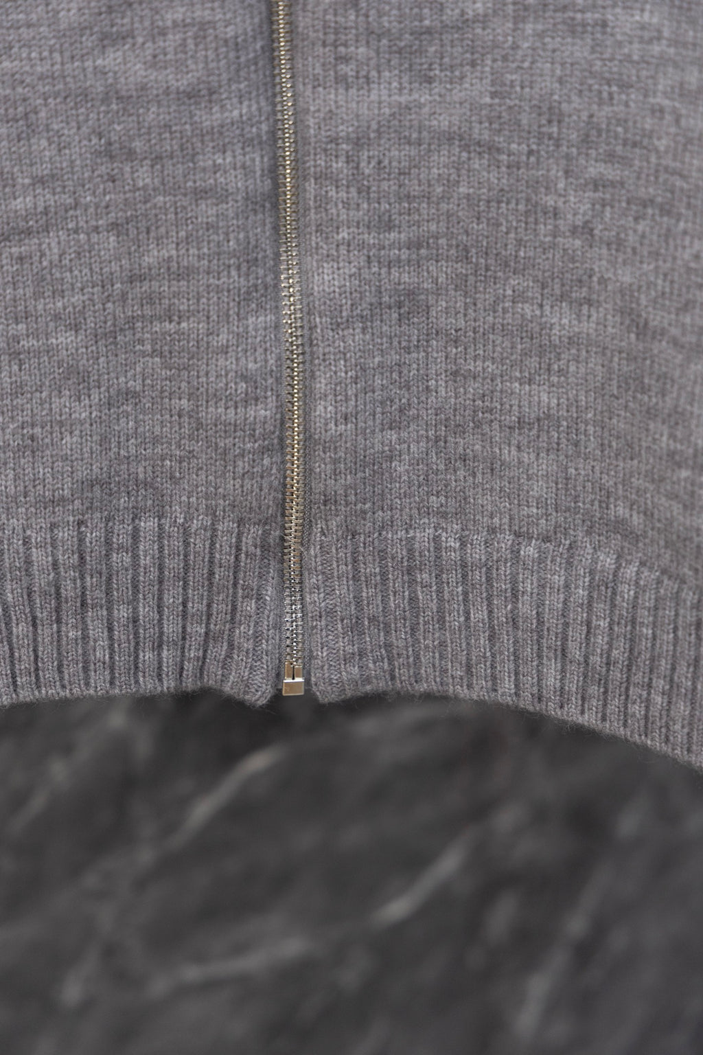 Gray Prada knit zip sweater center close-up with zipper and ribbed hem