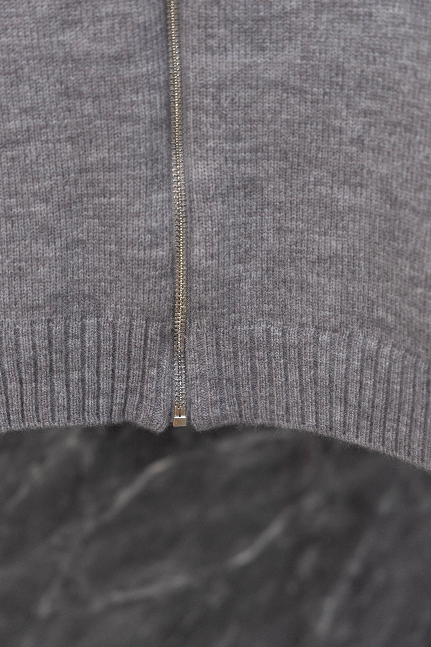 Gray Prada knit zip sweater center close-up with zipper and ribbed hem