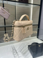 Cream mini top-handle handbag with quilted finish, zipper pocket, and gold chain