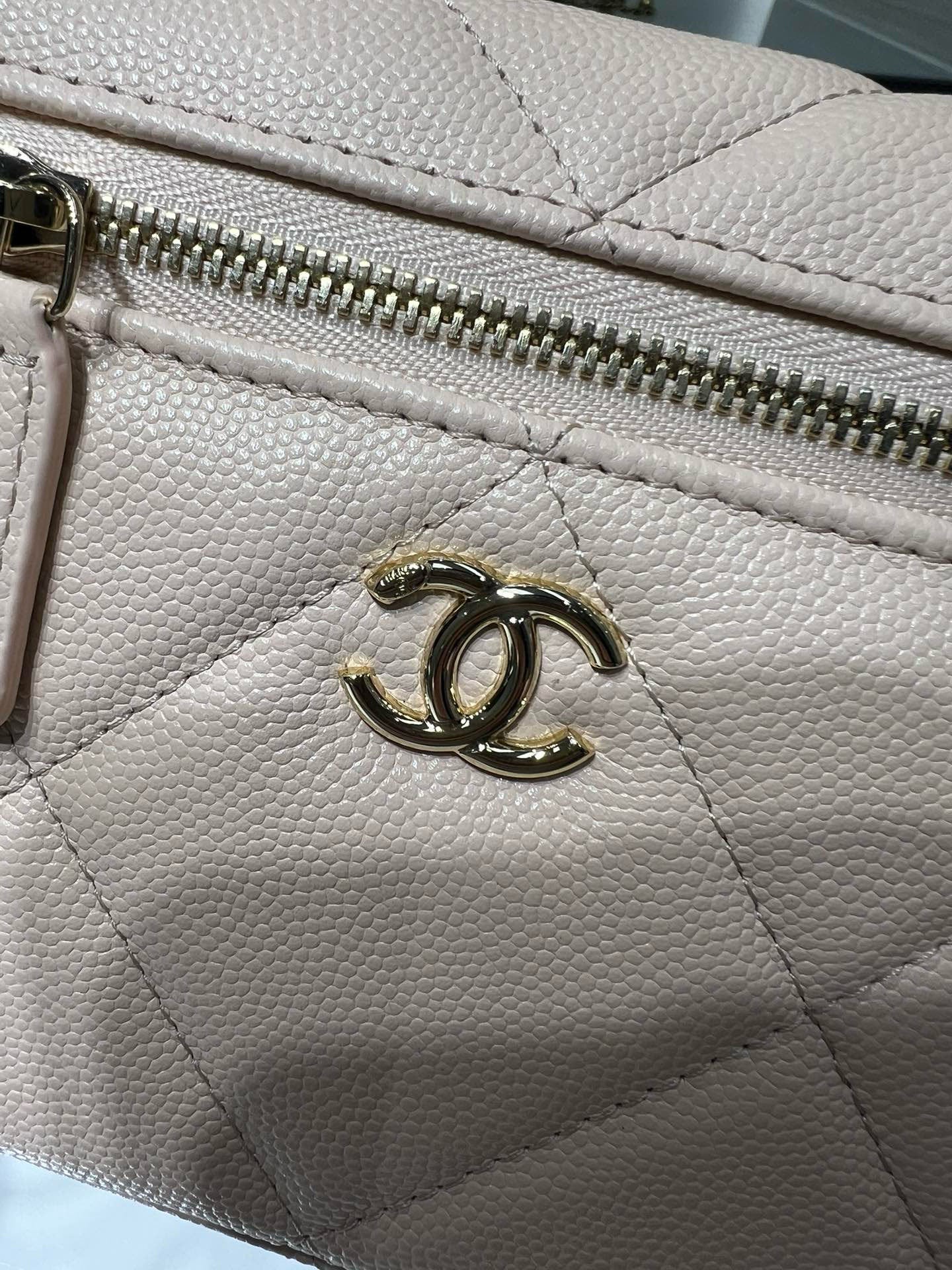 Cream leather zipper pull detail with gold-toned Chanel CC hardware