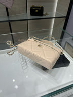 Cream quilted mini shoulder bag with gold chain strap and front zipper pull